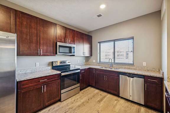 A kitchen with wooden cabinets and stainless steel appliances.