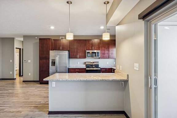A kitchen with a refrigerator, microwave, and oven.