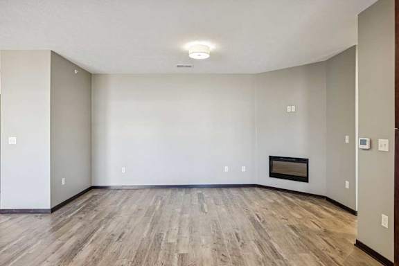 A room with a fireplace and wood flooring.