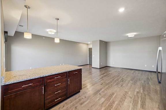 A spacious room with wooden floors and a granite countertop.