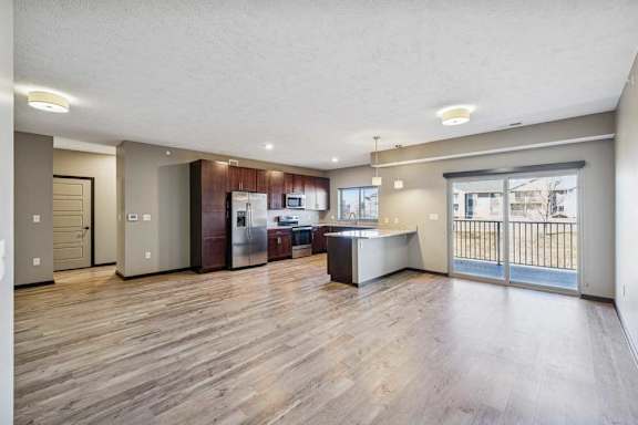A spacious kitchen with wooden floors and modern appliances.