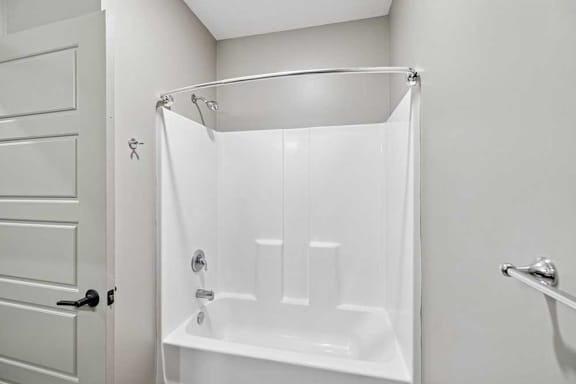 A white bathroom with a white tub and shower curtain.