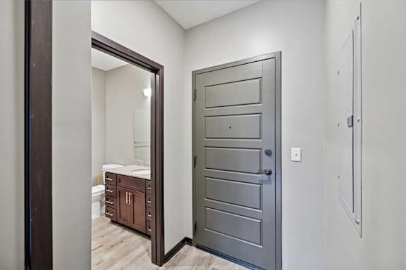 A bedroom with a large mirror and a wooden door.