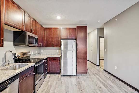A kitchen with wooden cabinets and stainless steel appliances.
