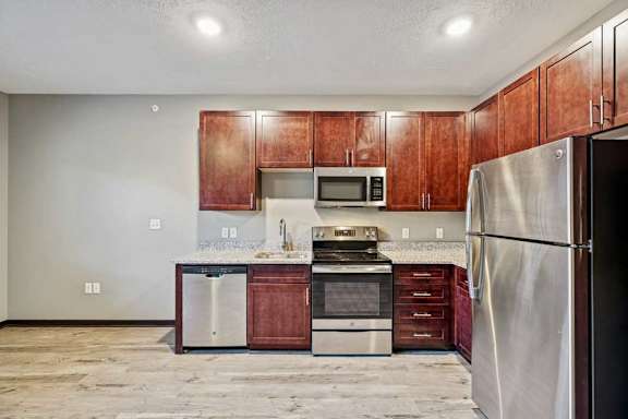 A kitchen with wooden cabinets and stainless steel appliances.