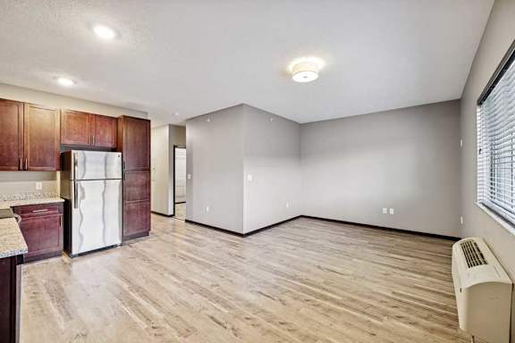 A kitchen with a refrigerator, cabinets, and a countertop.