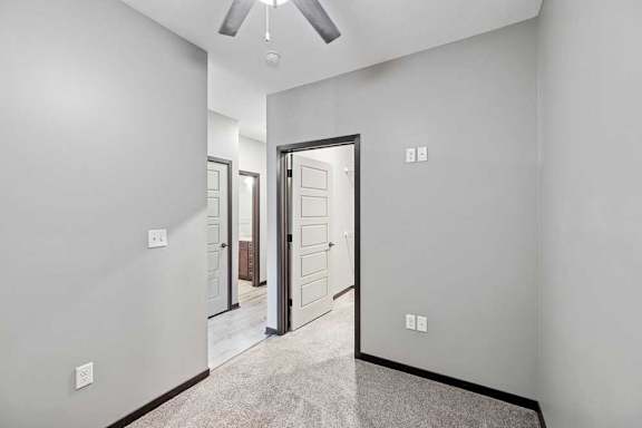 A room with a ceiling fan and a carpeted floor.