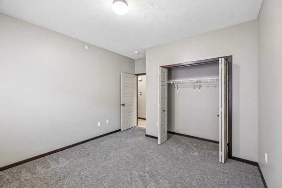 A room with a grey carpet and a white door.