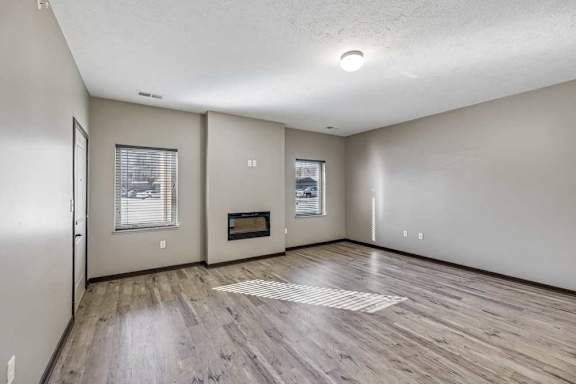 A spacious room with a wood floor and a window.