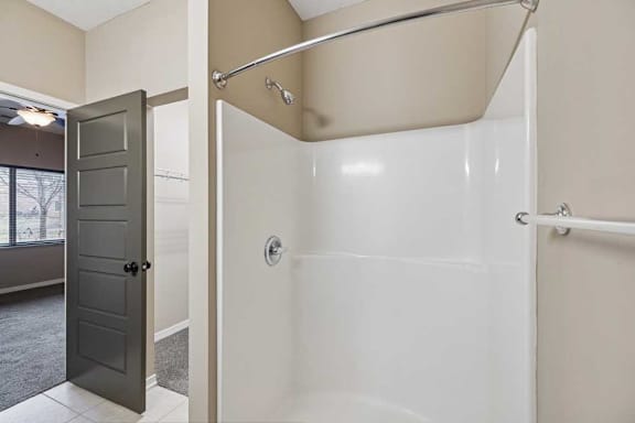 A bathroom with a walk-in shower next to a walk-in closet.