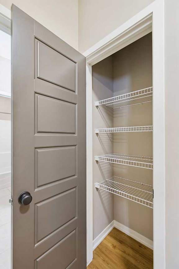 A kitchen pantry with several built-in wire shevles.