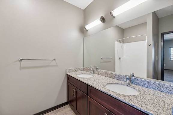 A bathroom with a double sink vanity and a towel bar.