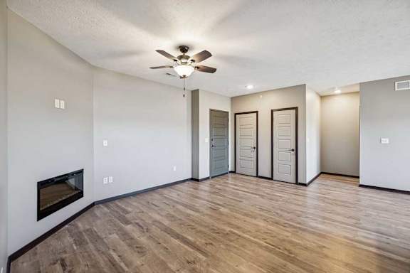 A room with a fireplace and wood flooring.