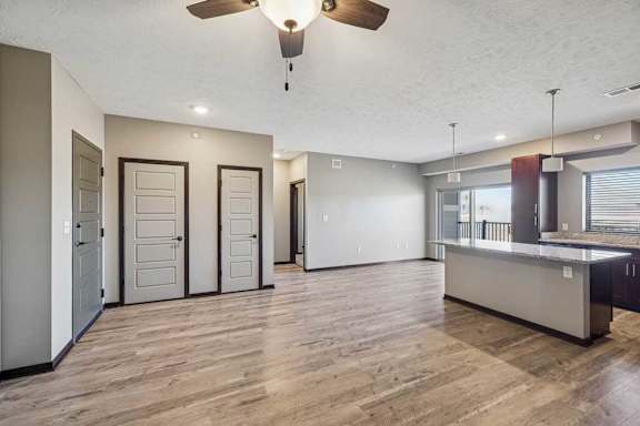 A room with a ceiling fan and wooden flooring.