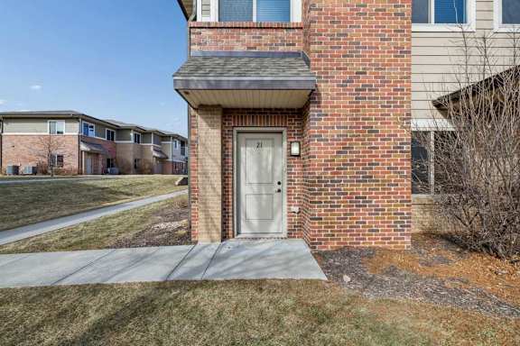 A front door with an awning, and a patio and sidewalk space.