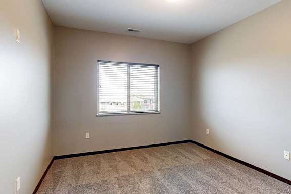 A room with a window and carpeted floor.