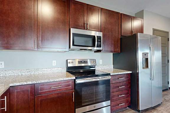 A stainless steel stove, microwave, and fridge in a contemporary kitchen.
