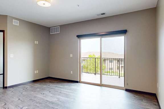 A living room with a large glass door leading to the balcony.