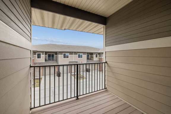 A balcony with a railing overlooking a building with multiple windows.