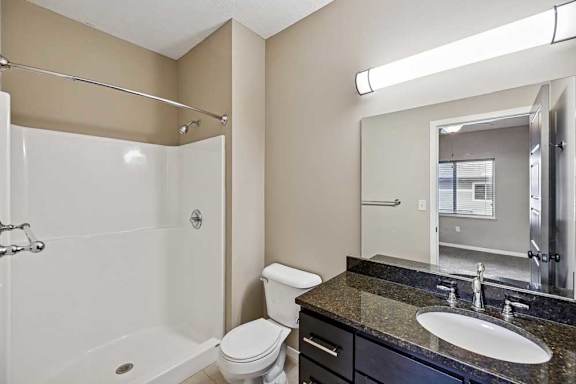 A bathroom with a white tub, sink, and toilet.