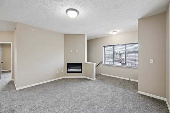 A living room with a fireplace and a window with blinds.