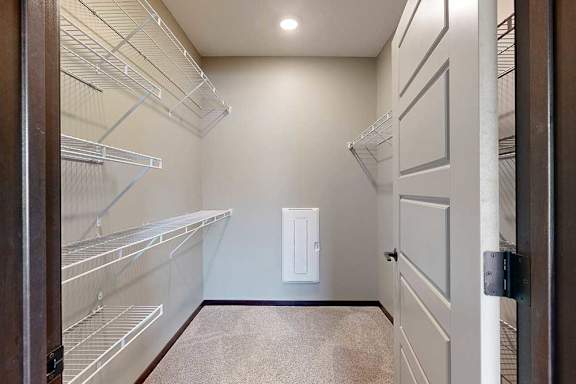 A long walk-in closet with built-in shelving and hanging space on either side.