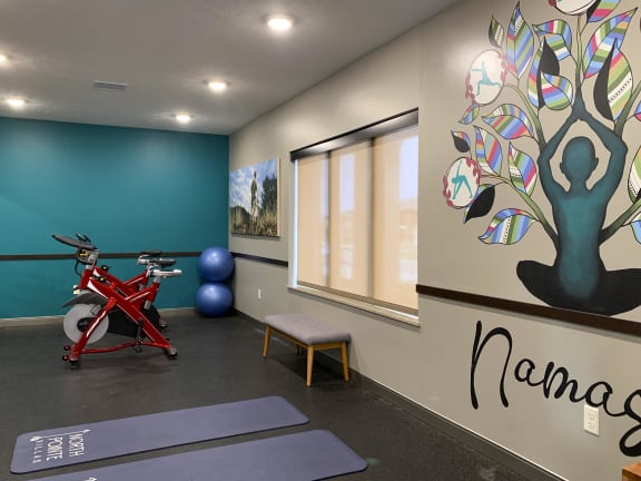 Yoga studio at North Pointe Villas with spin bikes, yoga mats and large yoga mural that reads