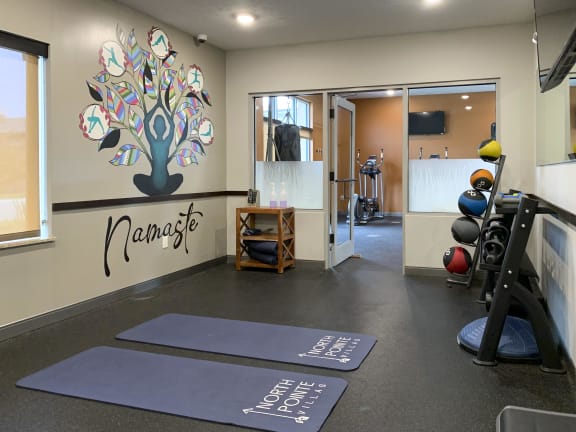 Yoga studio at North Pointe Villas with spin bikes, yoga mats and large yoga mural that reads