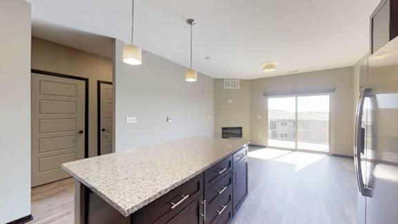 A kitchen with a granite countertop and stainless steel appliances.