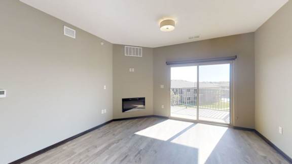 A room with a fireplace and sliding glass doors.