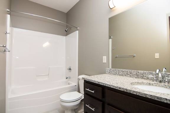 A white toilet sits next to a sink in a bathroom.