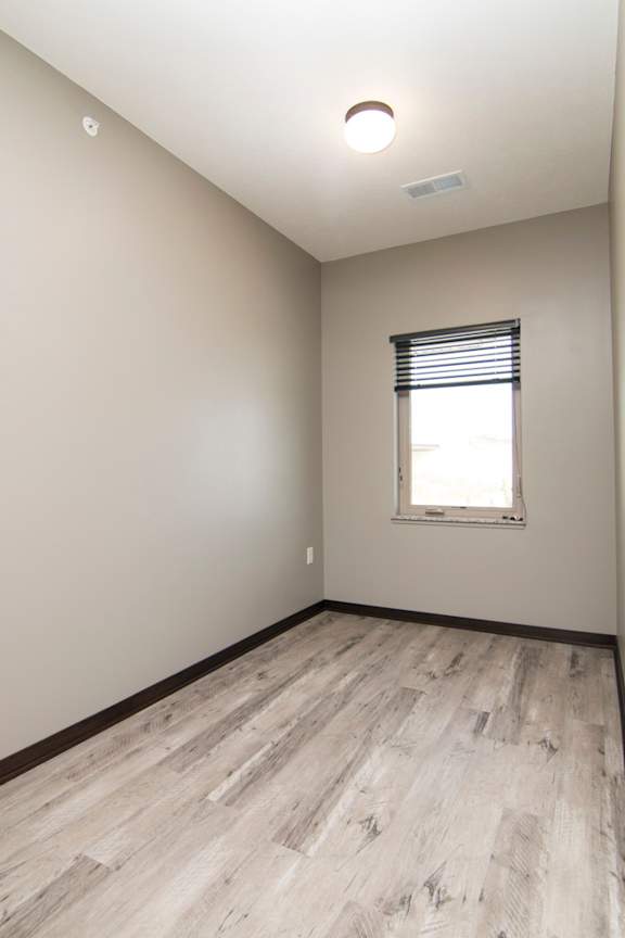 A room with a window and wooden flooring.
