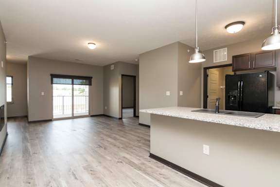 A kitchen with a black fridge and a white countertop.