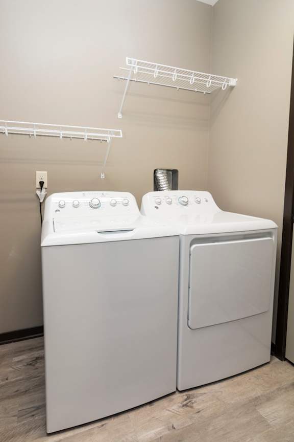 White washer and dryer with wire shelving above them