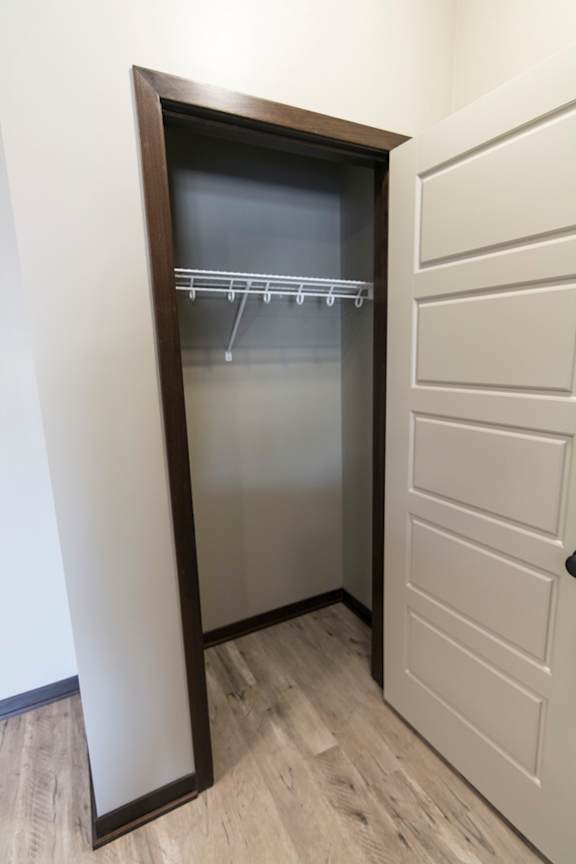 A white door with a black frame is open to a hallway.