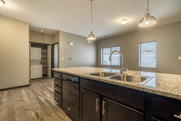 A kitchen with a sink and a refrigerator.