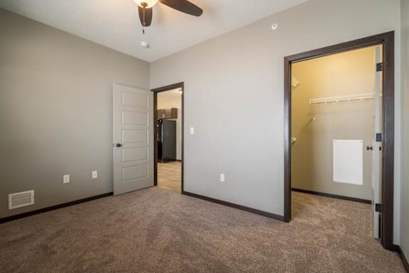 A room with a ceiling fan and two doors.