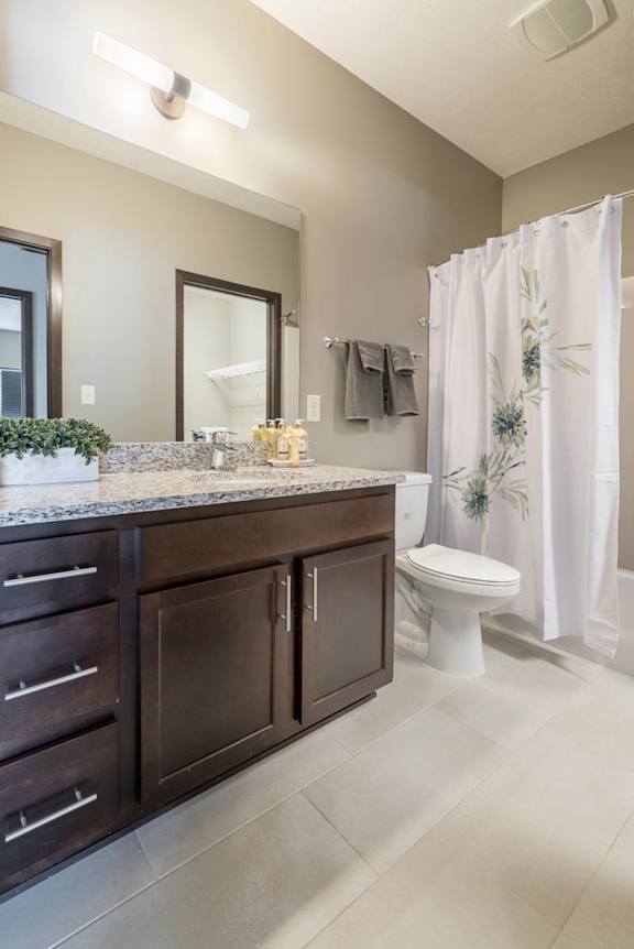 A bathroom with a white shower curtain and a white toilet.