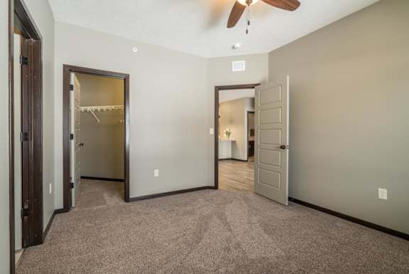 A room with a ceiling fan and a carpeted floor.