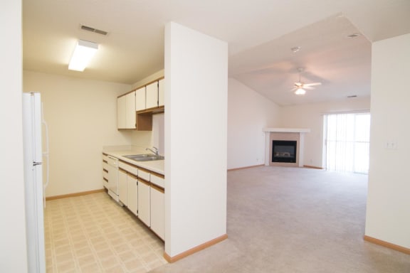 an empty kitchen and living room with a fireplace