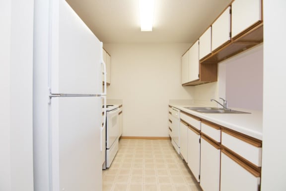 a kitchen with white cabinets and a white refrigerator