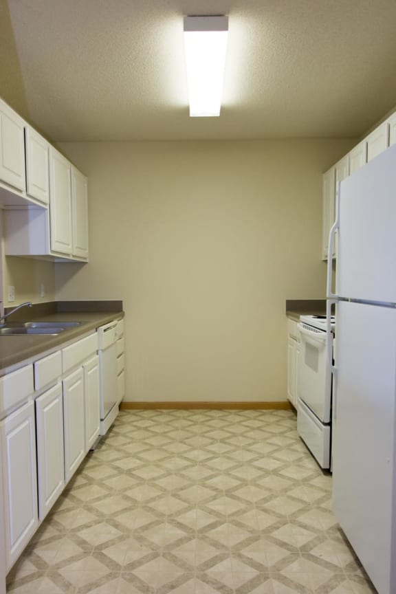 a kitchen with white cabinets and a white refrigerator