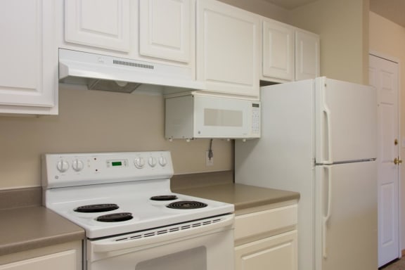 a kitchen with white appliances and white cabinets