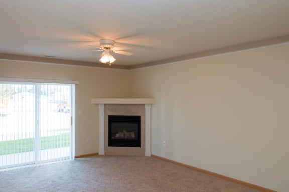 a living room with a fireplace and a ceiling fan