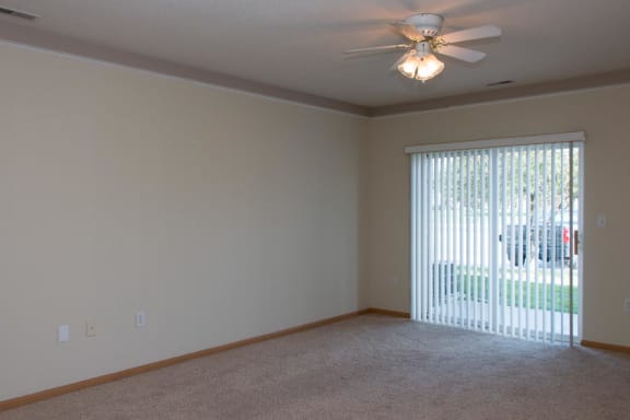 a living room with a large window and a ceiling fan