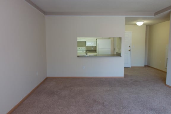 an empty living room with a kitchen in it