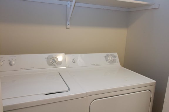 a white washer and dryer in an empty laundry room