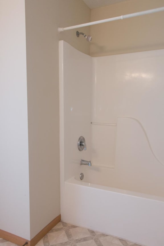 a white bath tub in a bathroom with a shower curtain