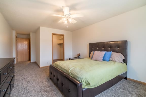 a bedroom with a large bed and a ceiling fan