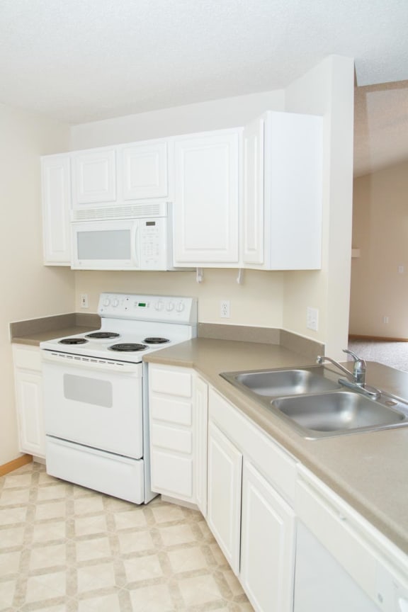 a kitchen with white appliances and white cabinets
